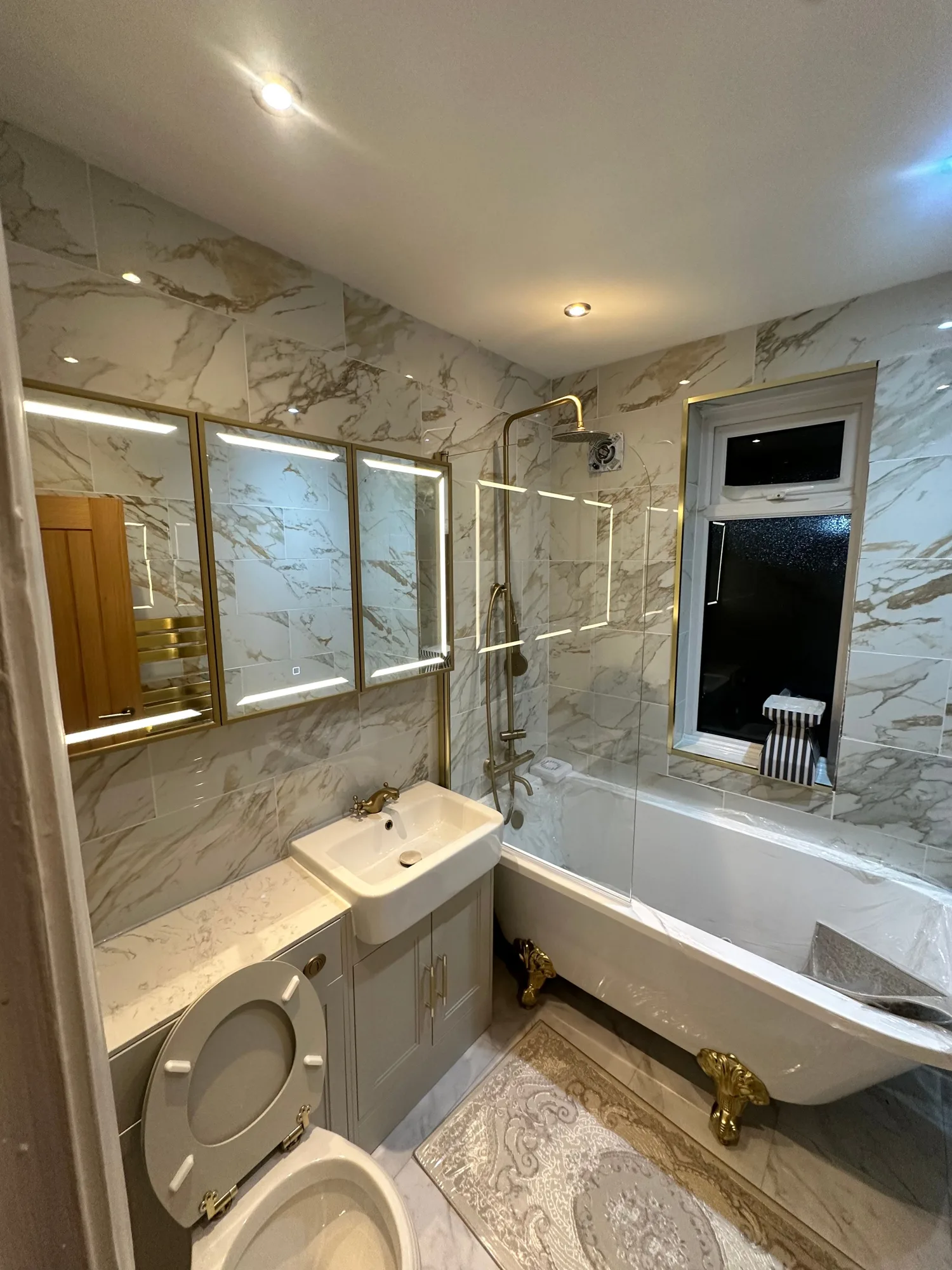 Bathroom with backlit LED mirror cabinets and downlights